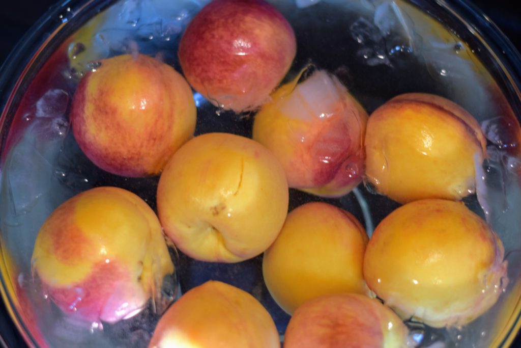 Pealed fresh peaches in ice water